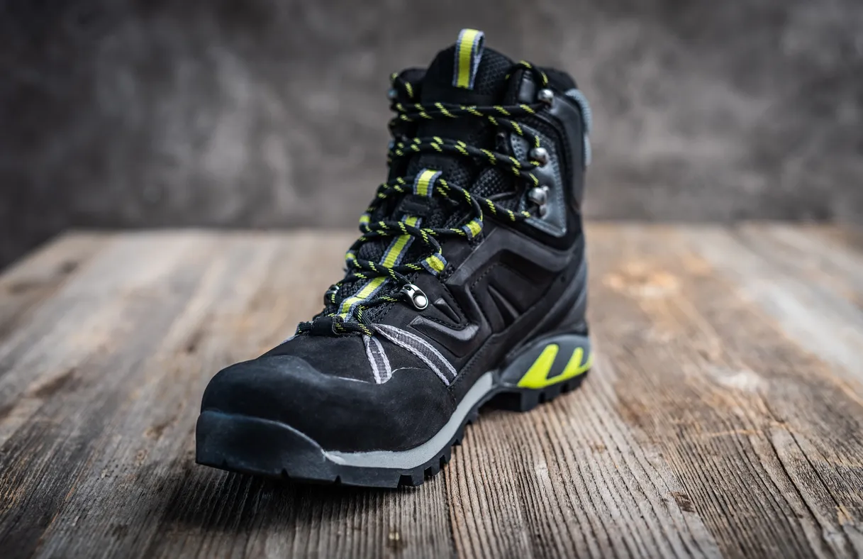 Importancia de las botas de seguridad: Fotografía de una bota de seguridad color negro con detalles color blanco y amarillo.